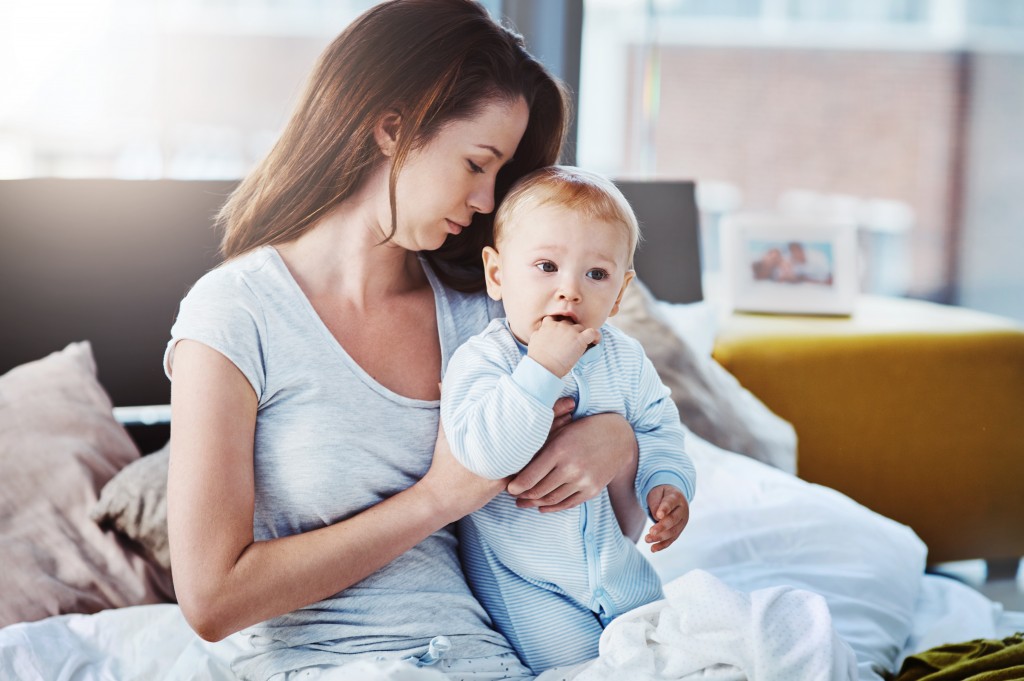 Mother with child sitting on the bed