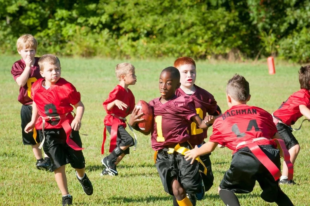 Boys playing rugby on field