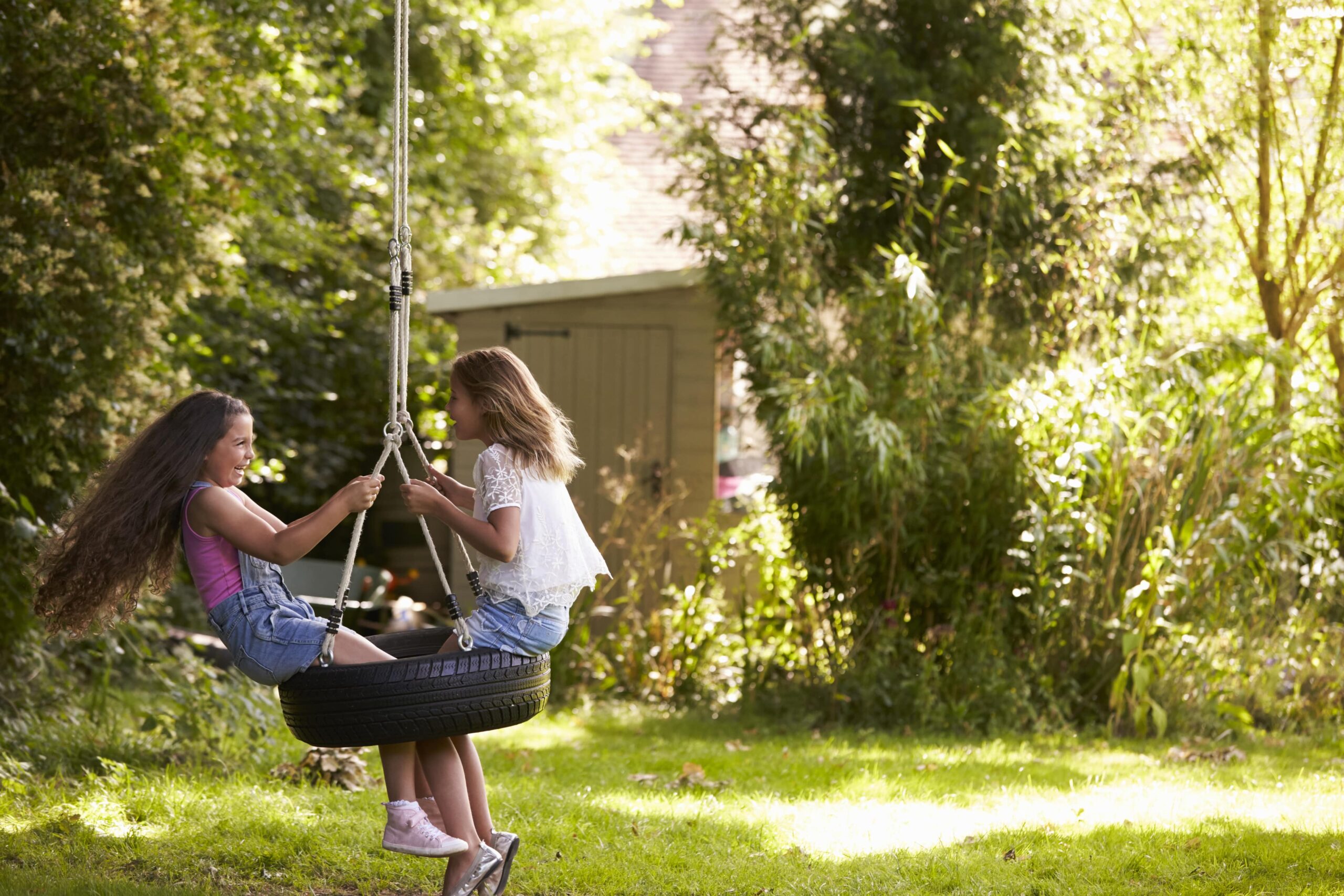 Girls playing on swing at summer camp