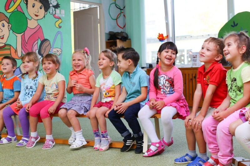 Kindergarten kids sitting on bench in class