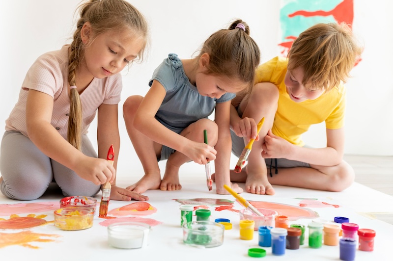 2 girls and a boy painting together