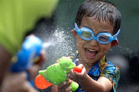 Boy with goggles and water gun celebrating Songkran