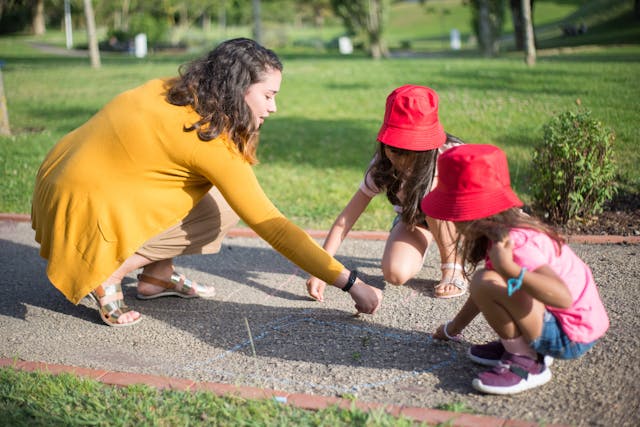 Woman with 2 girls wearing red hats